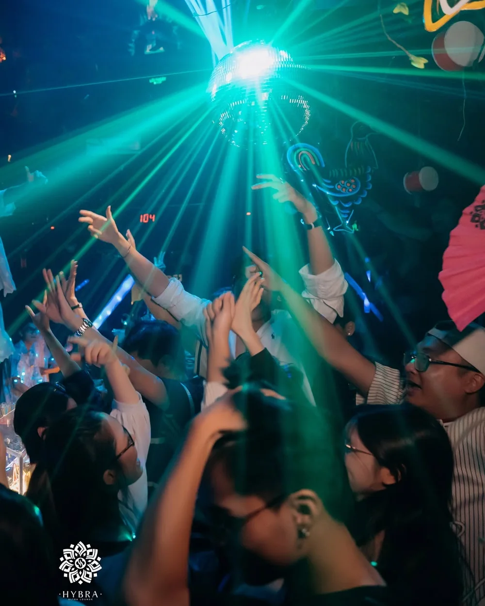 Quả cầu disco toả tia xanh trên cả sàn giơ tay tại HYBRA Ultra Lounge Hà Nội